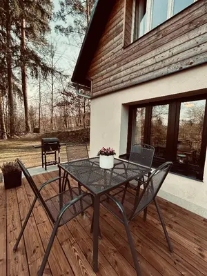 a kitchen with a table and a dining room at Cosy chalet with wellness in Mirošovice