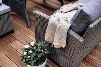 a wicker chair with a potted plant on a wooden floor at Vila Zlatý Slavík - Luxurious Villa with Spa in Jevany