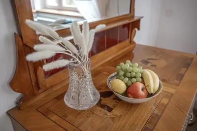 a vase sitting on a table with a bowl of fruit at Vila Zlatý Slavík - Luxurious Villa with Spa in Jevany