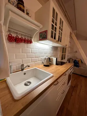 a kitchen with a white sink and wooden counters at Chatinka Kersku in Hradišťko