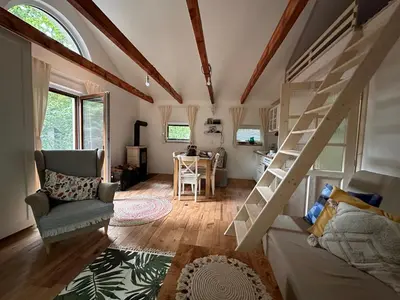 a living room with a loft bed and a table at Chatinka Kersku in Hradišťko