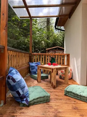 a patio with a table and chairs on a wooden deck at Chatinka Kersku in Hradišťko