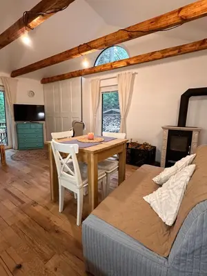 a dining room with a table and a bed at Chatinka Kersku in Hradišťko