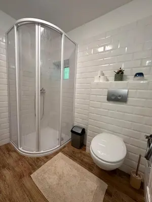 a white bathroom with a shower and a toilet at Chatinka Kersku in Hradišťko