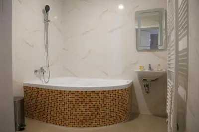 a bathroom with a tub and a sink at Arbes 20 - Family Suite in Prague