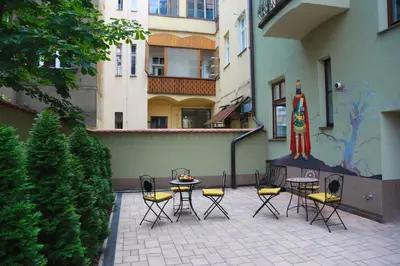 a patio with chairs and a table and a umbrella at Arbes 20 - Family Suite in Prague
