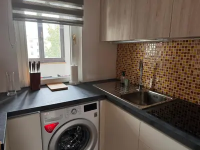 a kitchen with a washing machine and a sink at Arbes 20 - Family Suite in Prague