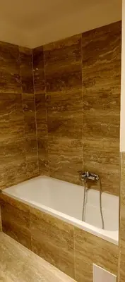a bath tub with a faucet in a bathroom at Brand new two room apartment #23 with FREE parking in the city center in Prague