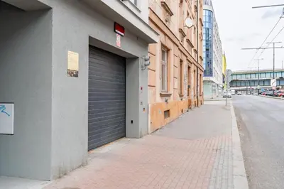 a building with a garage door on the side of a street at Brand new two room apartment #23 with FREE parking in the city center in Prague