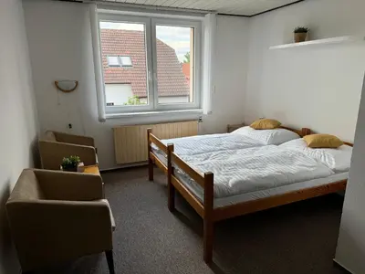 a bedroom with a bed and a window and a chair at Rodinný dům Poděbrady in Poděbrady