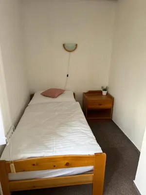 a small bedroom with a bed and a night stand at Rodinný dům Poděbrady in Poděbrady