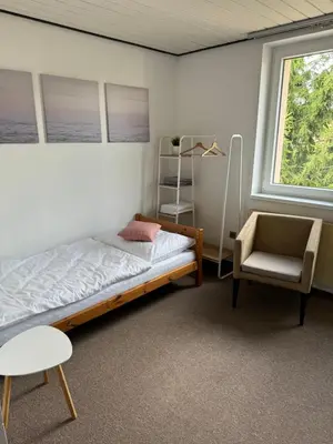 a bedroom with a bed and a chair and a window at Rodinný dům Poděbrady in Poděbrady