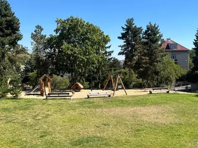 a playground with benches in a park with trees at Apartmán II centrum Praha in Prague