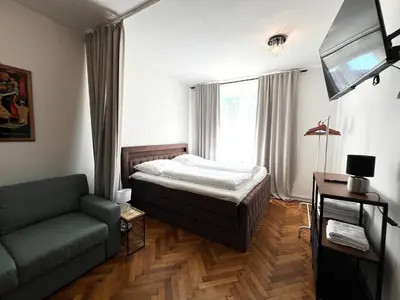 a bedroom with a bed and a couch and a television at Apartmán II centrum Praha in Prague