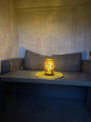 a candle sitting on a table in front of a couch at Maringotka u lesa in Staňkovice