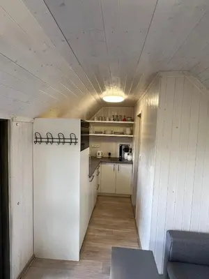 a small kitchen with white walls and a ceiling at Maringotka u lesa in Staňkovice