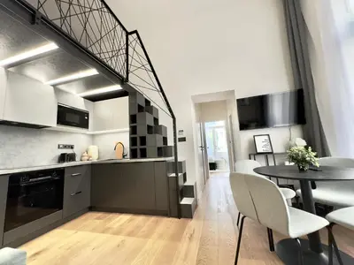 a kitchen and dining room with a spiral staircase in a apartment at Rentero Modern High Ceiling Loft with Terrace Apartment, Prague in Prague