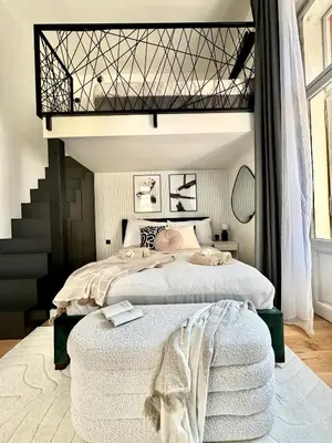 a bedroom with two beds and a staircase at Rentero Modern High Ceiling Loft with Terrace Apartment, Prague in Prague
