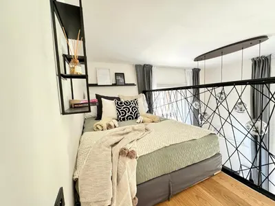 a bedroom with a bed and a balcony at Rentero Modern High Ceiling Loft with Terrace Apartment, Prague in Prague