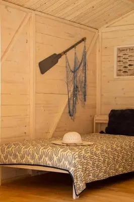 a bedroom with a bed in a wooden room at Ostende - Chatky u Sázavy in Chocerady