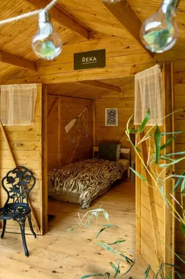 a room with a bed in a wooden cabin at Ostende - Chatky u Sázavy in Chocerady