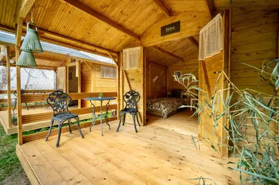 a room with two chairs and a bed in a cabin at Ostende - Chatky u Sázavy in Chocerady