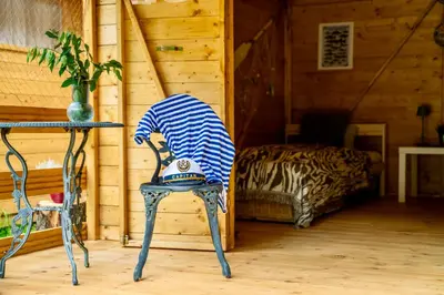 a blue and white chair in a room with a bed at Ostende - Chatky u Sázavy in Chocerady