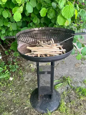 a charcoal grill with a bunch of wood on it at Ostende - Chatky u Sázavy in Chocerady