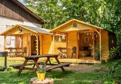 a wooden cabin with a picnic table in front of it at Ostende - Chatky u Sázavy in Chocerady