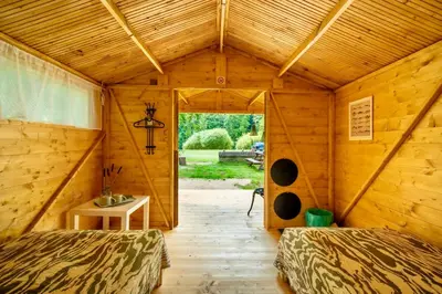 a room with two beds in a wooden house at Ostende - Chatky u Sázavy in Chocerady