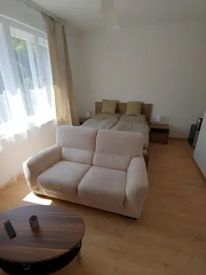 a living room with a white couch and a bed at Pension Nad Zlichovem in Prague