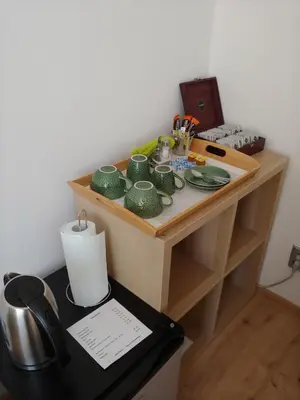 a desk with green cups and plates on it at Pension Nad Zlichovem in Prague