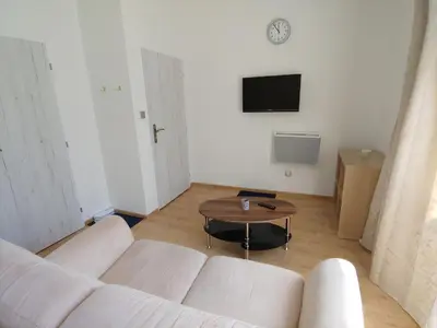 a living room with a white couch and a table at Pension Nad Zlichovem in Prague
