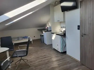 a kitchen with a table and chairs in a room at Komárov Apartment in Beroun