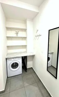 a laundry room with a washing machine and a mirror at Hillside Studios in Prague