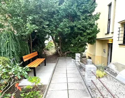 a park bench sitting next to a building at Hillside Studios in Prague