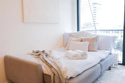 a couch with towels on it in a living room at Rentero Modern, River View Apartment near Prague City Center in Prague