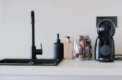 a kitchen counter with a coffee maker and a blender at Rentero Modern, River View Apartment near Prague City Center in Prague