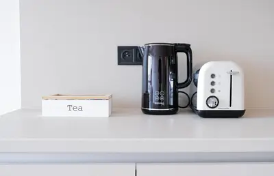 a coffee maker and a toaster sitting on a counter at Rentero Modern, River View Apartment near Prague City Center in Prague