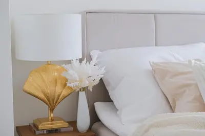 a bed with a lamp on a night stand next to a bed at Rentero Modern, River View Apartment near Prague City Center in Prague