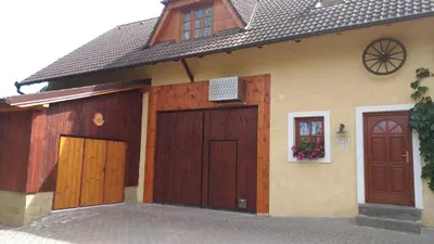a house with two wooden garage doors on it at U Prejzků in Lhotka