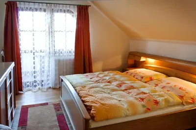 a bedroom with a bed and a large window at U Prejzků in Lhotka