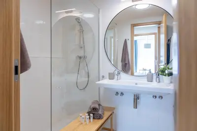 a bathroom with a shower and a sink and a mirror at Prague Days - Two-bedroom Apartment with Balcony and Garage Parking in Smíchov in Prague