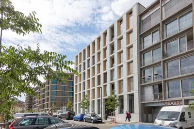 a tall building with cars parked in front of it at Prague Days - Two-bedroom Apartment with Balcony and Garage Parking in Smíchov in Prague