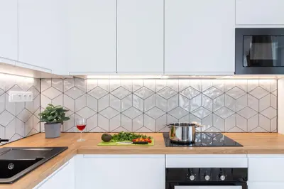 a kitchen with a counter top with a glass of wine at Prague Days - Two-bedroom Apartment with Balcony and Garage Parking in Smíchov in Prague
