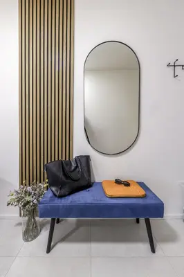 a mirror sitting on a blue bench with a purse at Prague Days - Two-bedroom Apartment with Balcony and Garage Parking in Smíchov in Prague