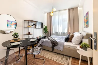 a bedroom with a bed and a table and a mirror at Prague Days - Studio with Netflix in Old Town in Prague