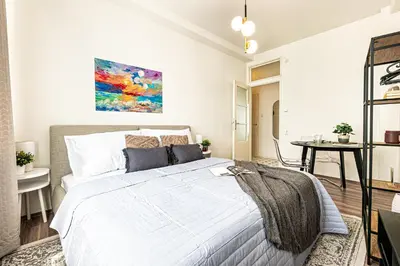 a bedroom with a white bed and a table at Prague Days - Studio with Netflix in Old Town in Prague