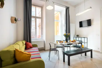 a living room with a green couch and a table at Hybernska Apartments by Pragueforyou in Prague