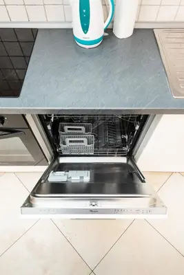 an open dishwasher under a counter in a kitchen at Hybernska Apartments by Pragueforyou in Prague
